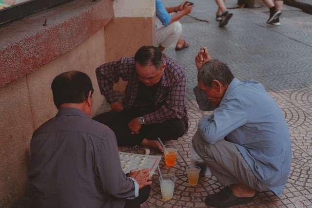 A group of men on the street playing a board game together