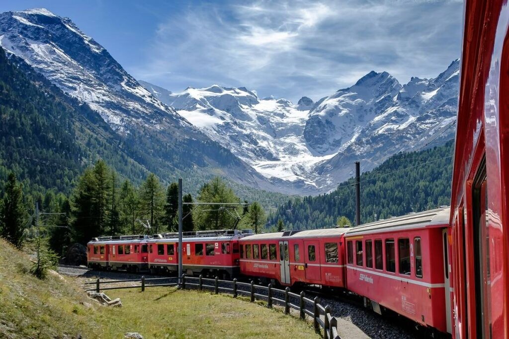 The bernina express passing by mountains in the alps
